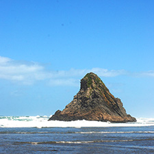 Ein Felsen in der Meeresbrandung als Symbol für eine professionelle Interessensvertretung und Beratung.