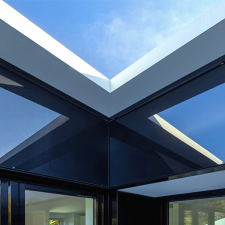 Als Bild für das Projekt Modernisierung 70er Jahre Architektur die Innenecke einer schwarzen Glasfassade mit Spiegelungen.