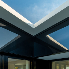 Innenecke des Penthouse aus einer Vorhangfassade aus schwarzem Glas mit spiegelung der Dachkanten.